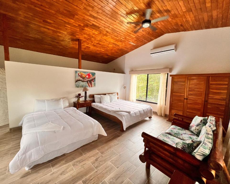 a bedroom with two beds and a wooden ceiling at Blue Banyan Inn in Quepos