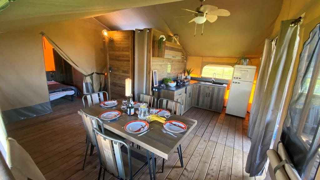 a dining room with a table and a kitchen at Camping à la ferme - Hébergements insolites in Cerisy-la-Forêt