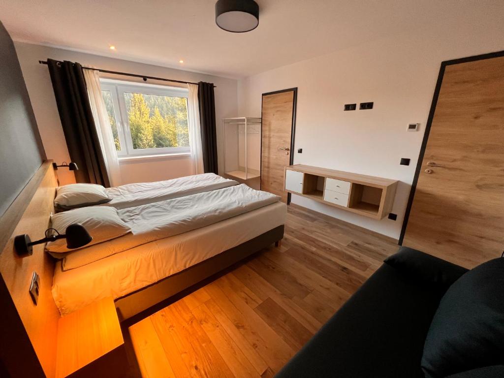 a bedroom with a bed and a window at NORDIC Apartamente Păltiniș in Păltiniş