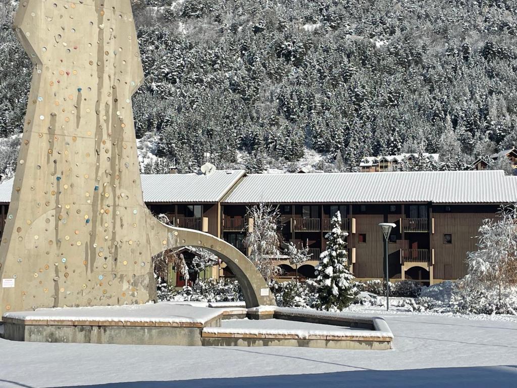 un bâtiment avec une grande sculpture dans la neige dans l'établissement Grand Sud, à La Salle Les Alpes
