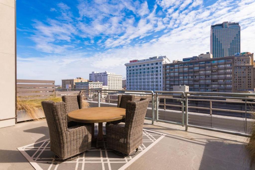 d'une table et de chaises sur un balcon avec vue sur la ville. dans l'établissement Modern Condo with Game Room in Downtown New Orleans, à La Nouvelle-Orléans