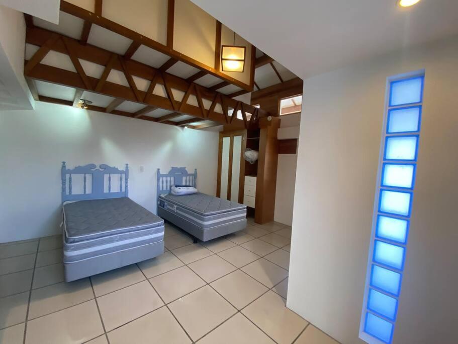 Habitación con 2 camas y ventana en Beautiful apartment in the heart of Puerto Ayora, en Puerto Ayora