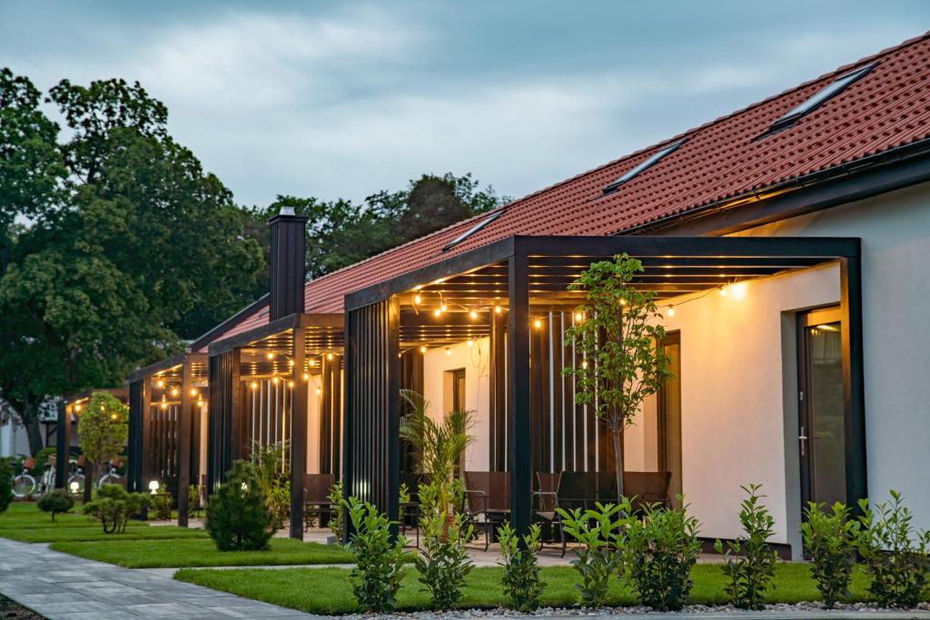 a house with lights on the side of it at Apartamenty Pod Dębami in Sarbsk