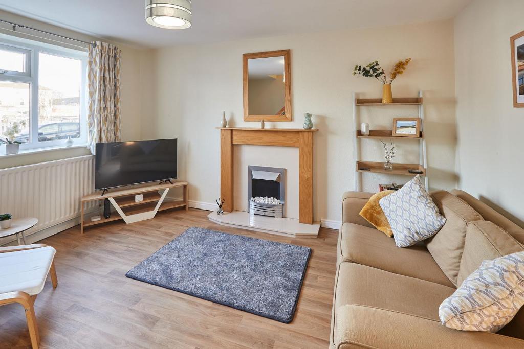 ein Wohnzimmer mit einem Sofa und einem Kamin in der Unterkunft Host & Stay - Station Cottage in Saltburn-by-the-Sea