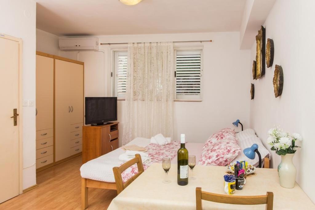 a room with a table and a bed and a television at Apartment Stella Polaris in Dubrovnik