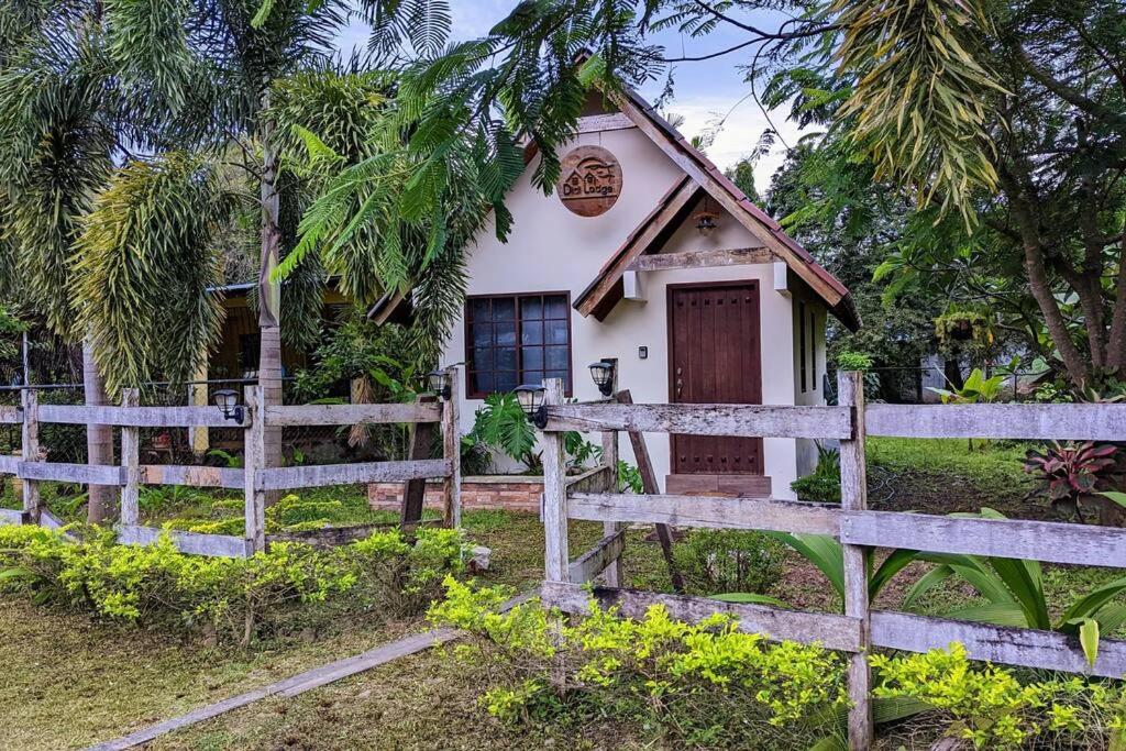 uma pequena casa com uma cerca em frente em Didi Lodge - Cabaña cálida y acogedora! em Cañas