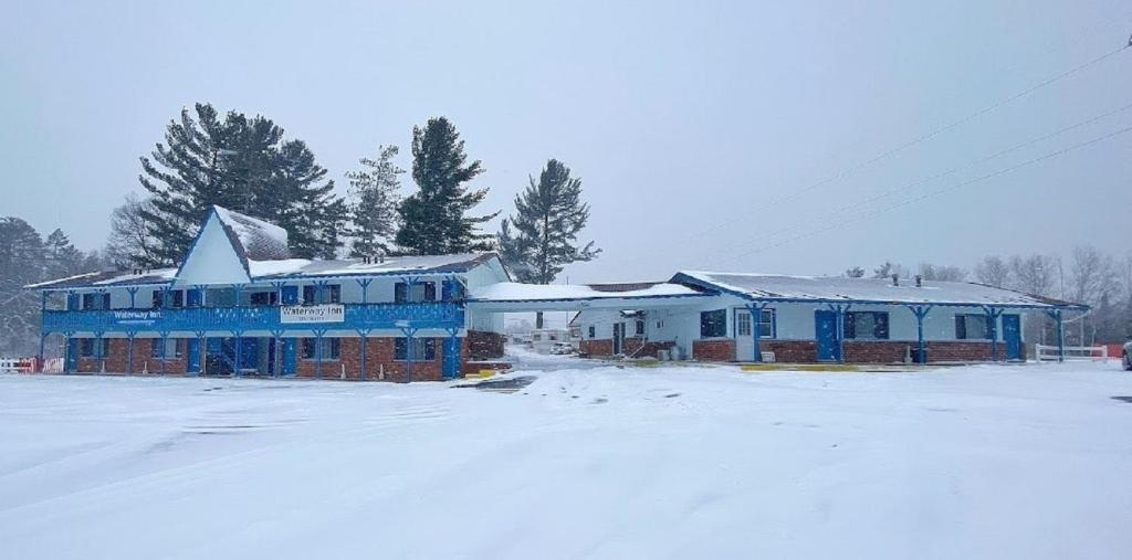 a building with snow on the ground in front at Waterway Inn in Indian River