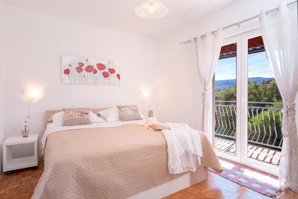 Biała sypialnia z łóżkiem i balkonem w obiekcie Apartment Katarina Vrboska w mieście Vrboska