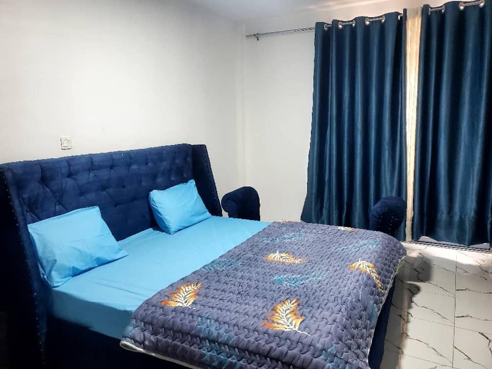 1 dormitorio con 1 cama con edredón azul en Kigali Center Apartment-1Bedroom, en Kigali