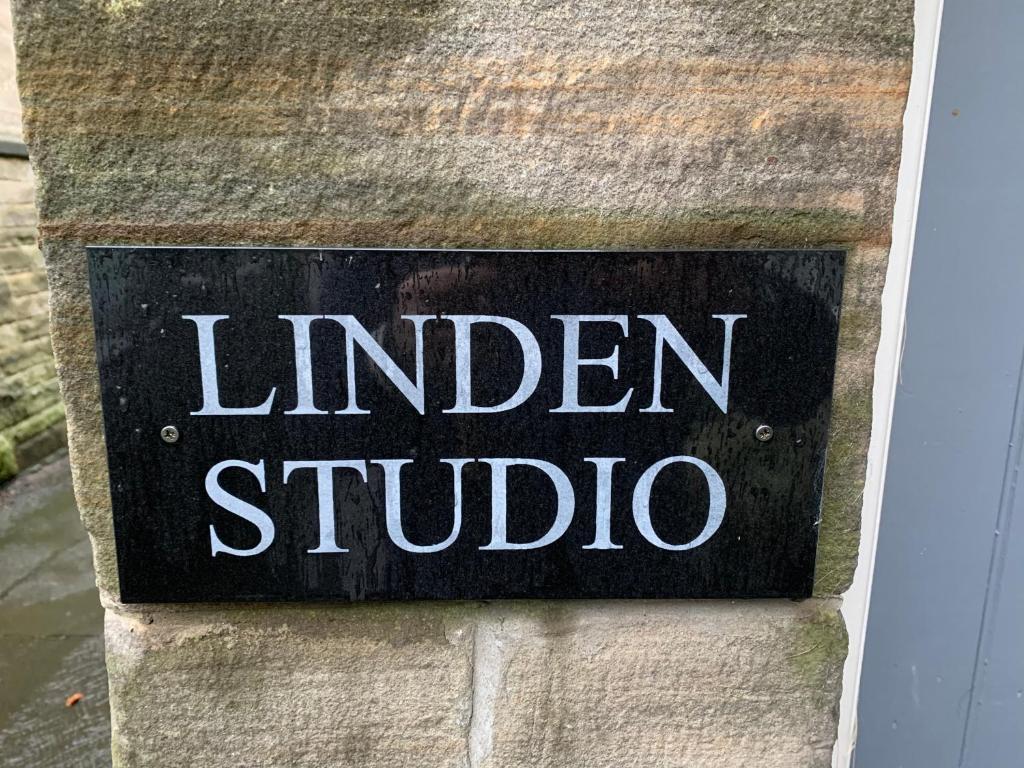 un panneau sur un mur de briques avec les mots studio linéaire dans l'établissement Linden Studio, à Morpeth