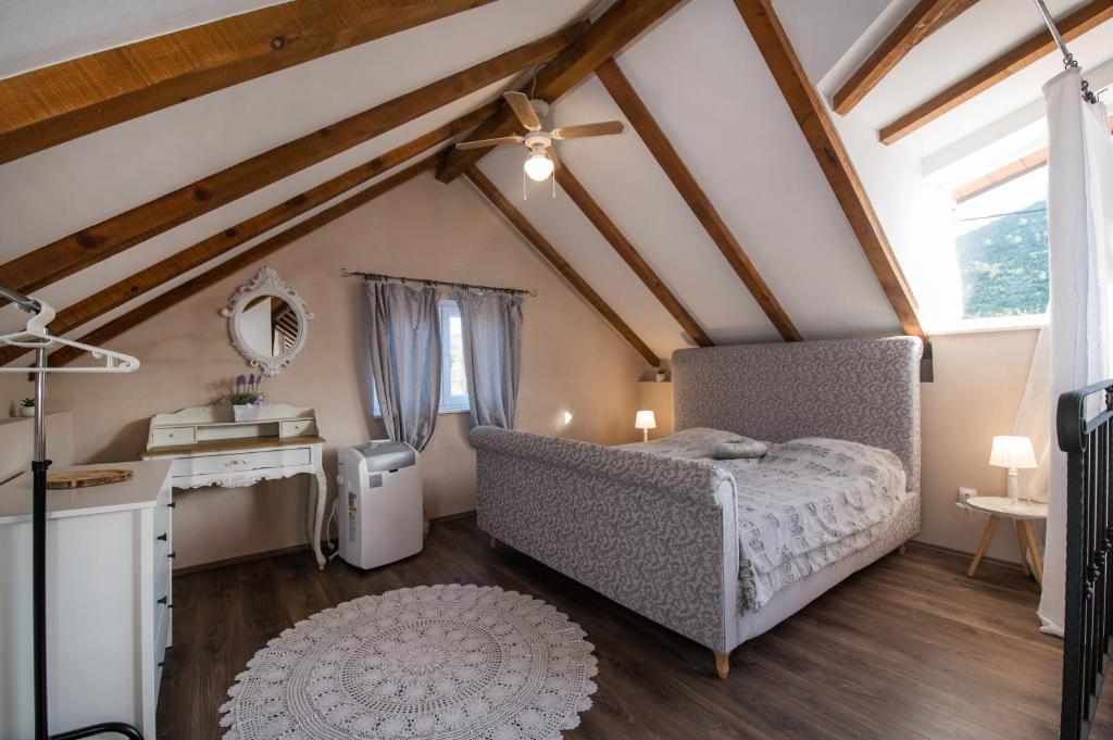 una camera da letto mansardata con letto e specchio di Vila Veranda a Donji Seget