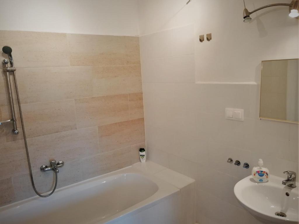 a bathroom with a bath tub and a sink at Zsuzsanna Vendégház in Gyomaendrőd