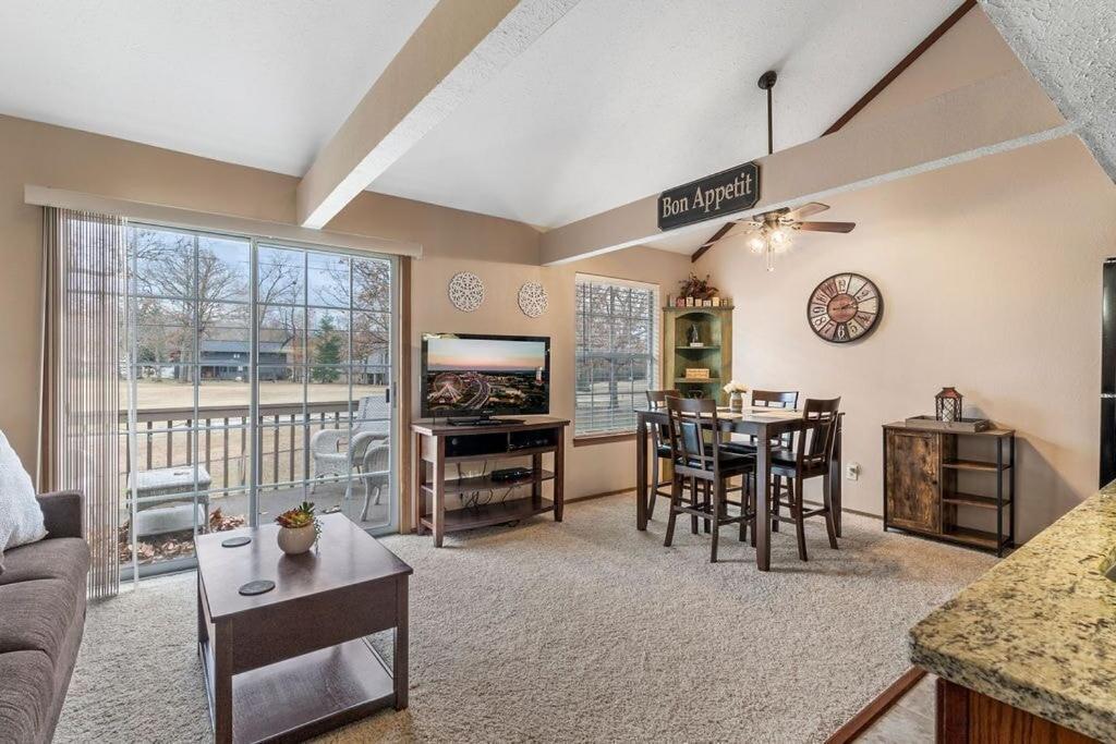 a living room with a couch and a table with a television at 2 Bed 2 Bath Fall Creek Condo in Branson