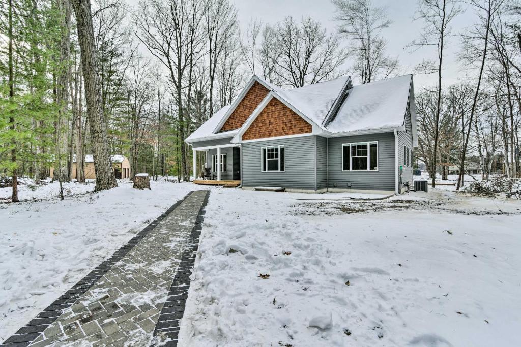 een huis is bedekt met sneeuw met een oprit bij Pet-Friendly Wixom Lake Home with Deck! in Beaverton