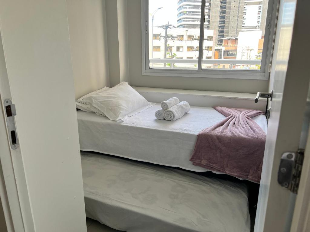Cama pequeña en habitación con ventana en Apartamento prox a Beira Mar, en Fortaleza