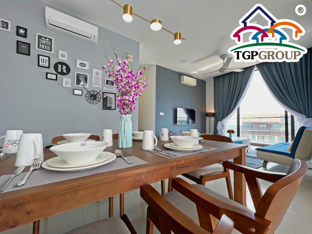 ein Esszimmer mit einem Tisch mit Stühlen und einem Tischoberteil für Gruppen in der Unterkunft D'Pristine Design Apartment by TGP in Nusajaya