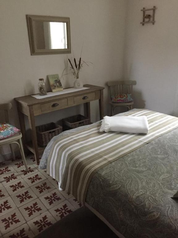 a bedroom with a bed and a table and a mirror at Maison au bord de mer in Saintes-Maries-de-la-Mer