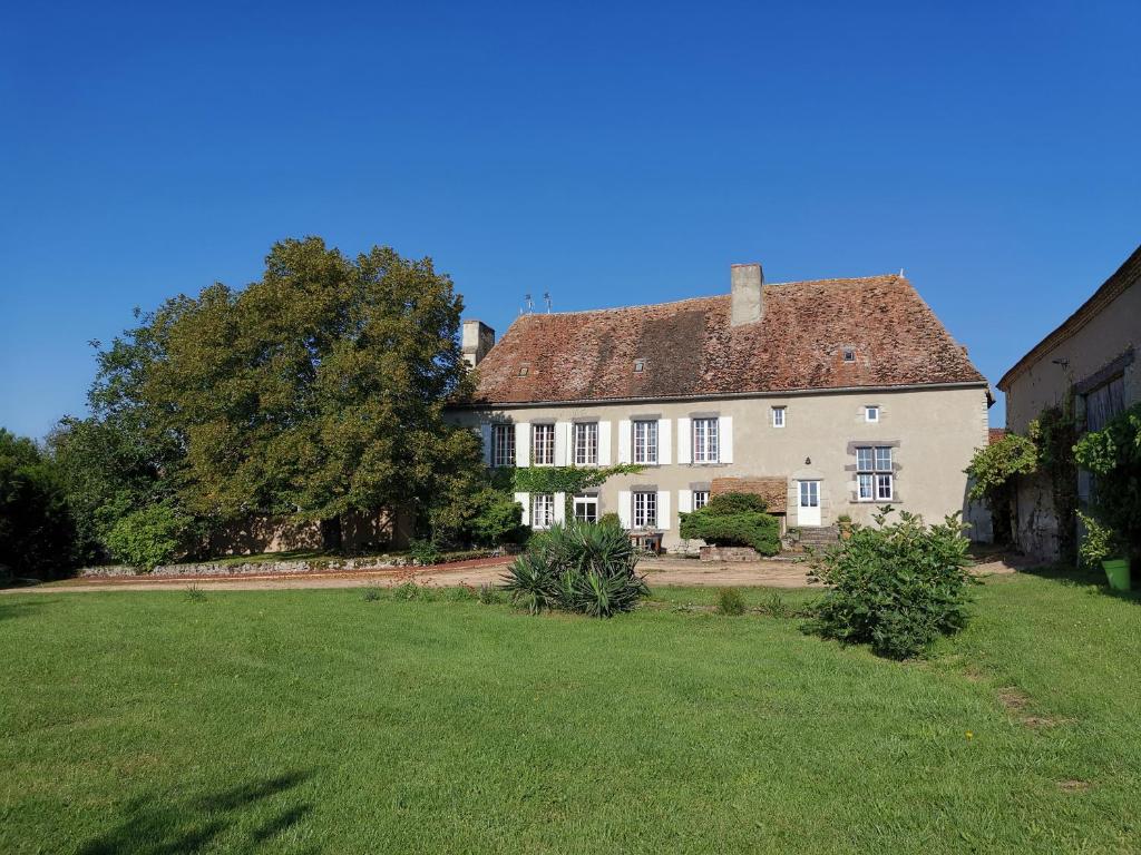a large white house with a large yard at Chambres d'hôtes Domaine des Formes in Effiat