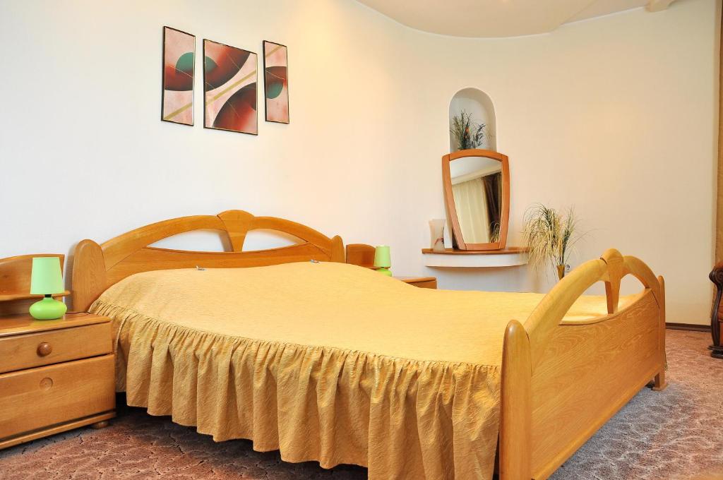 - une chambre avec un lit en bois et un miroir dans l'établissement Vila Classic, à Galaţi
