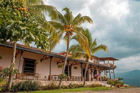 uma casa com palmeiras em frente ao oceano em Hotel Hacienda La Fe em Bucaramanga