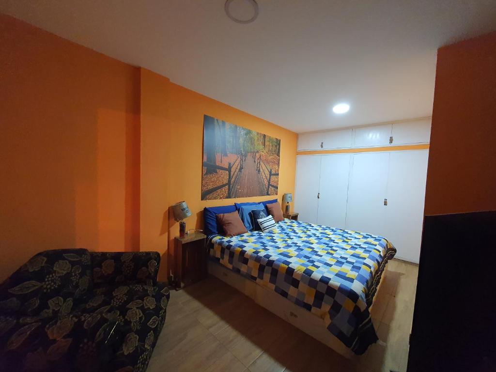 1 dormitorio con 1 cama y una pintura en la pared en El Rincón de las orquideas, en Concepción de Ataco