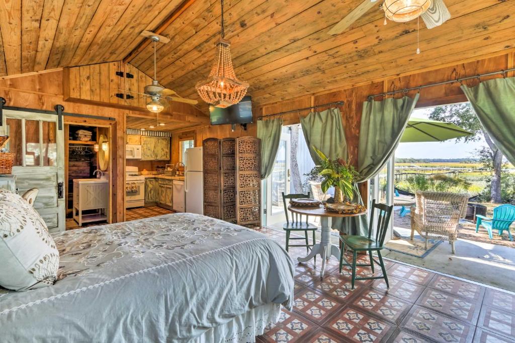 a bedroom with a bed and a table and a kitchen at Romantic Waterfront Getaway in Midway, GA! in Fancy Hall