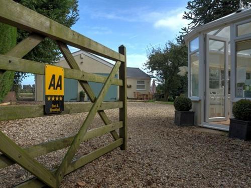 una puerta de madera con una señal frente a una casa en The White Horse View B&B, en Shrivenham