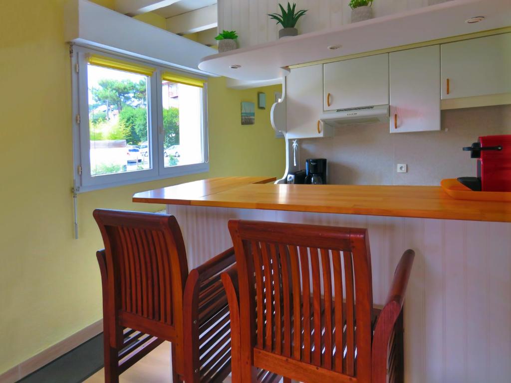 una cocina con 2 sillas de madera y una barra en Lodge Mendia en Anglet