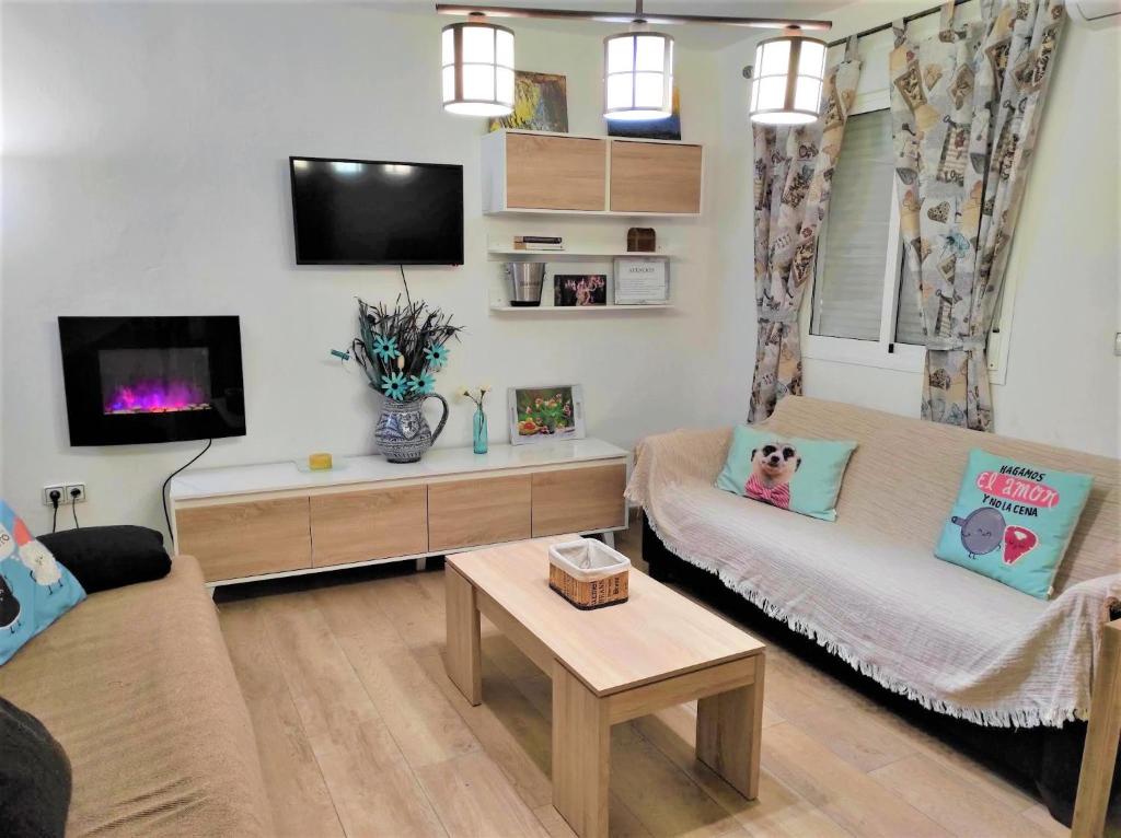 sala de estar con sofá y TV en La Villa, en El Burgo