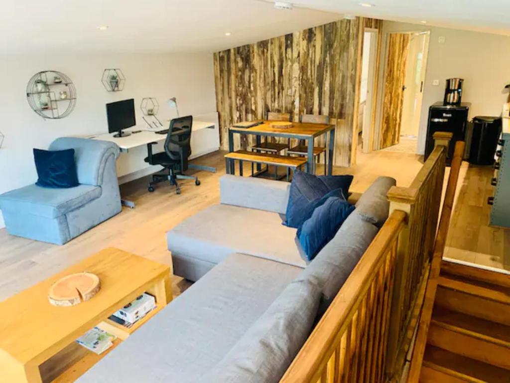 uma sala de estar com um sofá e uma secretária em Countryside Retreat Loft Apartment 