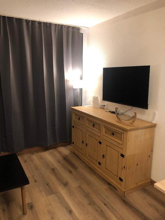 a living room with a television on a wooden cabinet at Appartement Alpe-d&#39;Huez 4 Personnes in L&#39;Alpe-d&#39;Huez