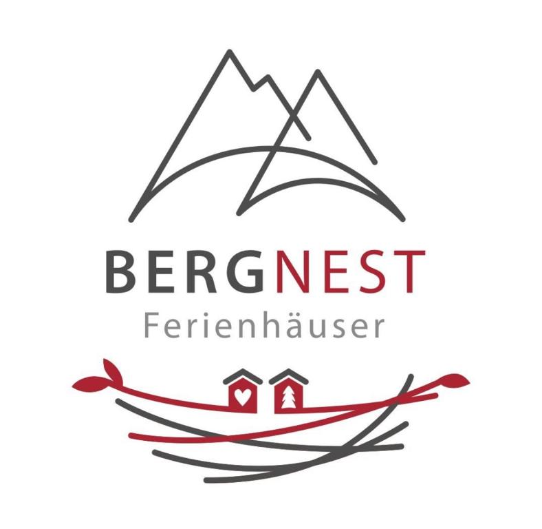 un barco con un logotipo de casa y montañas en BergNest Ferienhäuser "Haus mit Herz" en Arnoldshammer