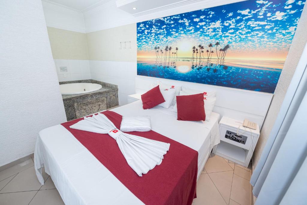 um quarto com uma cama com um quadro na parede em Expo Hotel em São Paulo