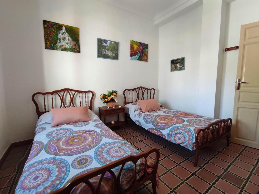 1 dormitorio con 2 camas y mesa en Casa Rural El Sendero, en El Burgo