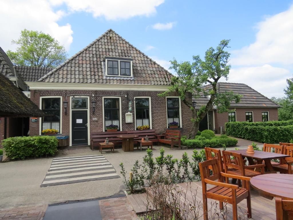 een huis met een patio met tafels en stoelen bij Hotel - Restaurant - Cafe- Geertien in Blokzijl