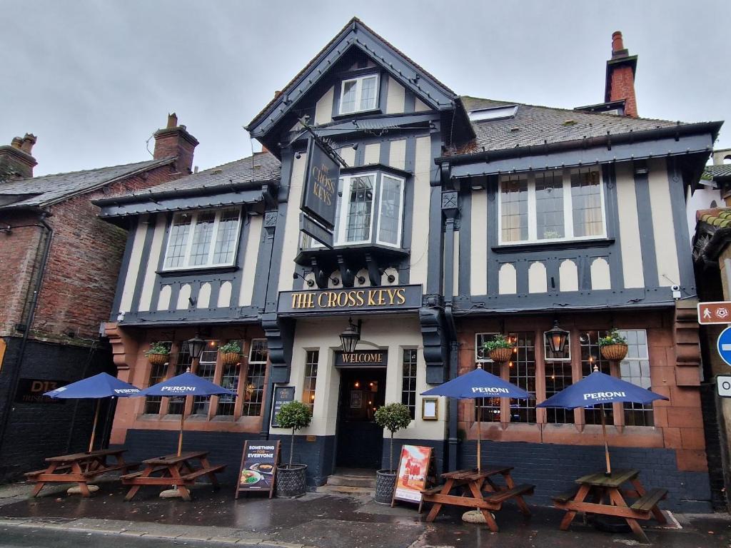 um edifício a preto e branco com mesas e guarda-chuvas em The Cross-Keys Hotel em Knutsford