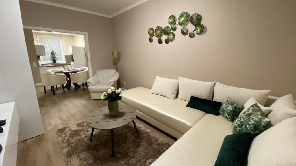 a living room with a white couch and a table at Liget Hévíz Apartman in Hévíz