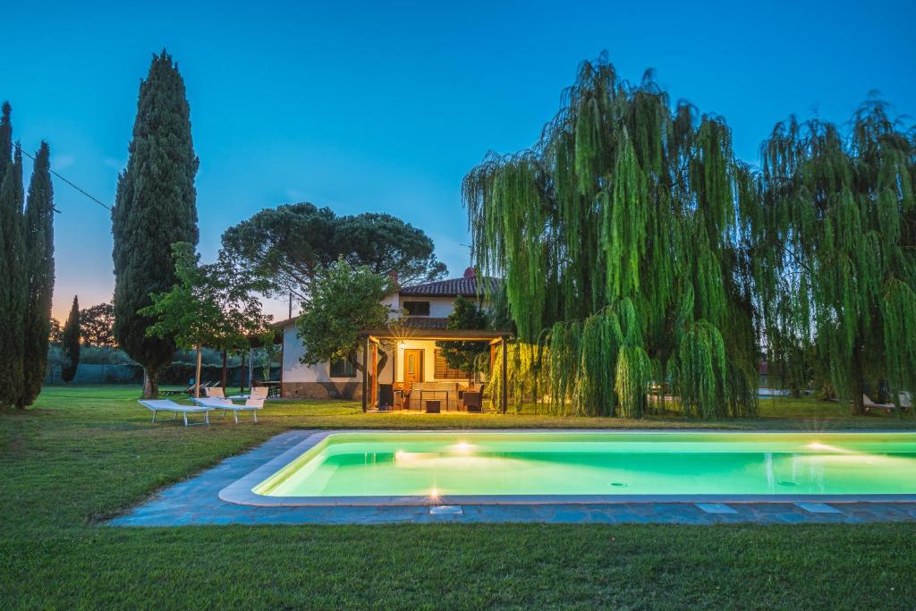 een zwembad in de tuin van een huis met een boom bij Villa Leonardo in Sarteano