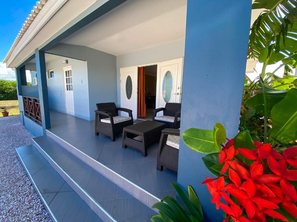 a view of the front porch of a house with red flowers at Benito Home in Tera Kora