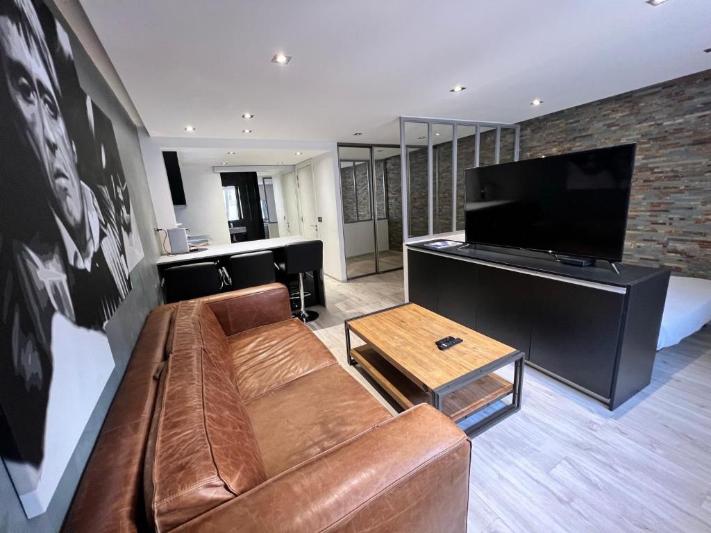 a living room with a couch and a flat screen tv at Appartement Design Centre ville in Saint-Tropez