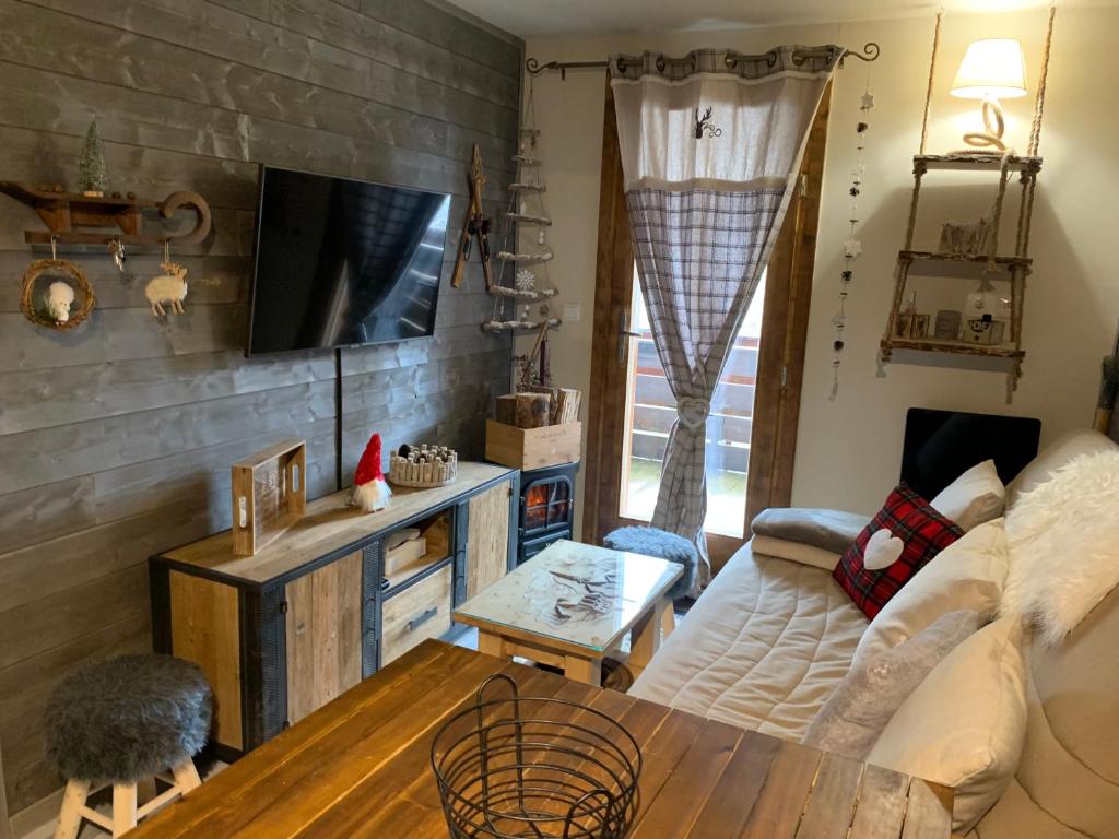 ein Wohnzimmer mit einem Sofa und einem Tisch in der Unterkunft Charmant T2 La Foux d’Allos, 5 pers in Allos