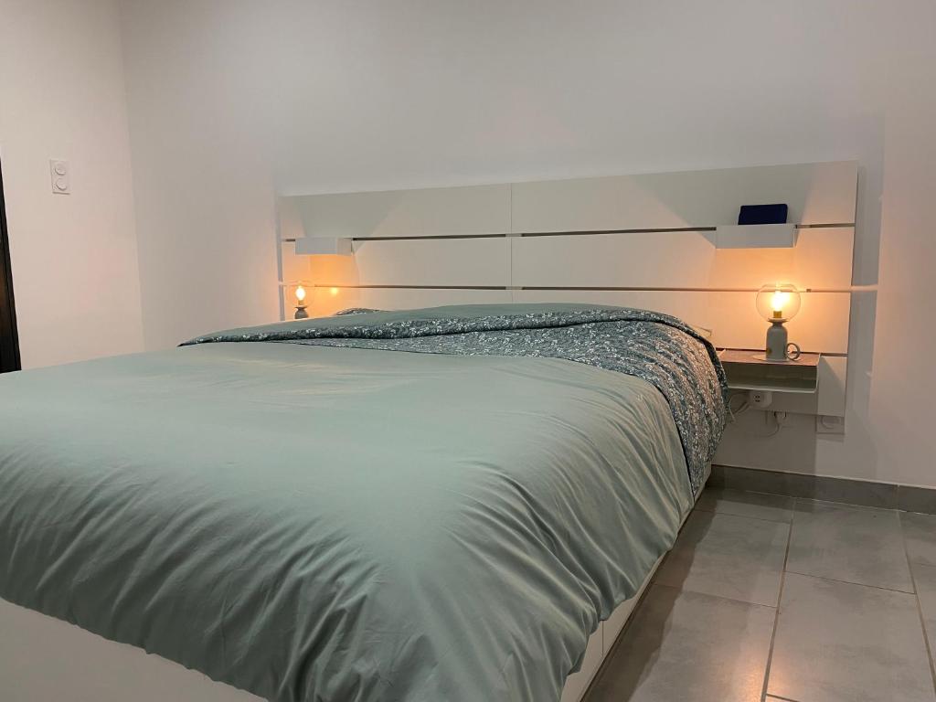 ein Schlafzimmer mit einem Bett und einem Schreibtisch mit zwei Lampen in der Unterkunft "Les cigales" aux portes de la Provence in Bollène