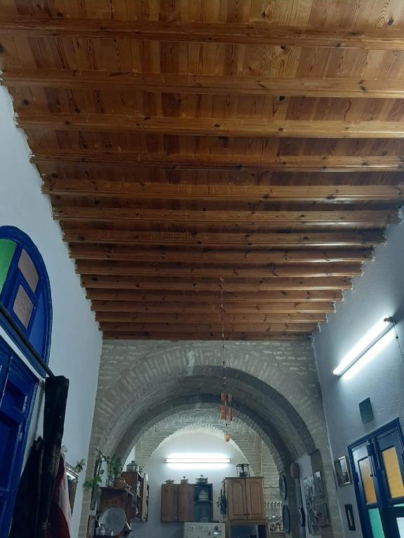 a wooden ceiling in a room with a stone wall at Maison d'hôte Chama in Kairouan