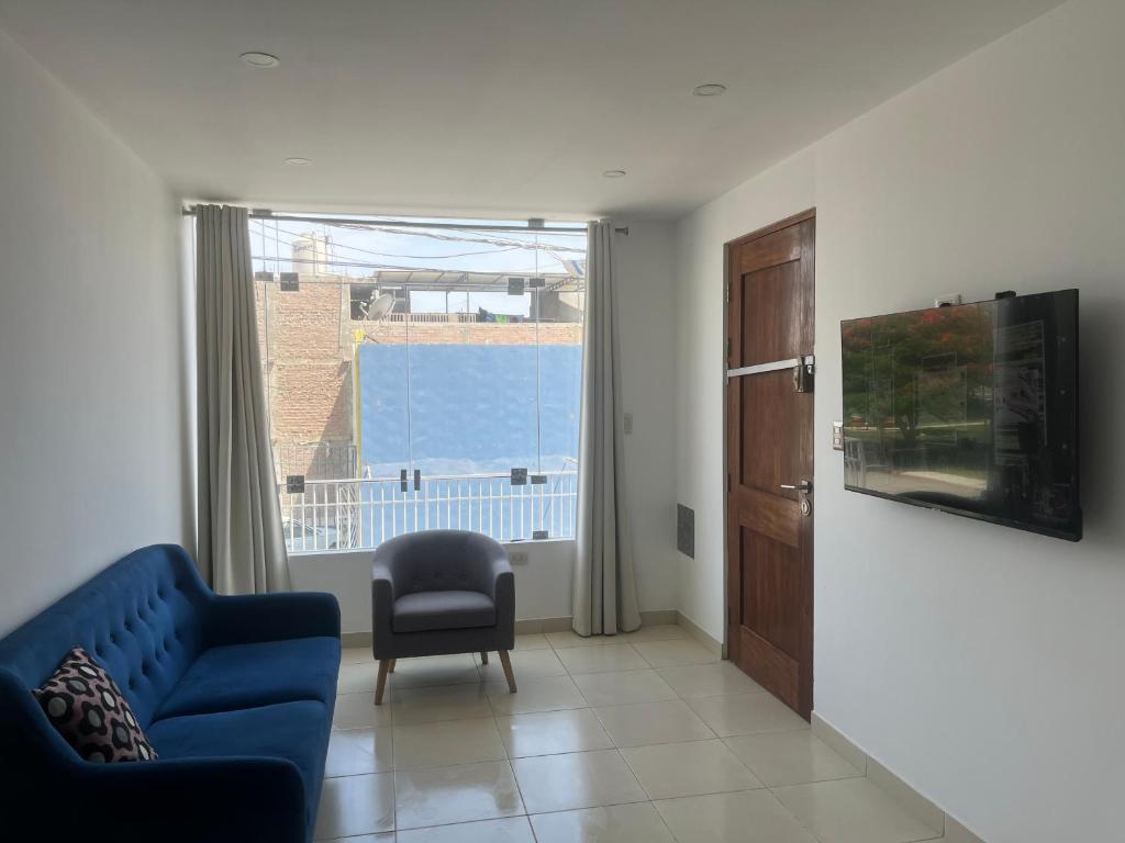 a living room with a blue couch and a window at Apartamento en Ica 2 in Ica