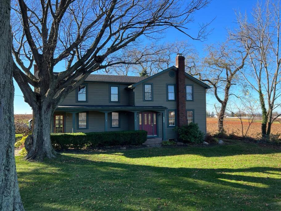 une maison grise avec un arbre dans la cour dans l'établissement Spacious 5 BR Home w/ Hot Tub, à North East