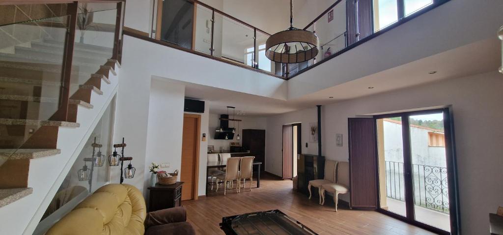 a living room with a staircase and a dining room at Los Ríos - Sierra de Gata in Torre de Don Miguel