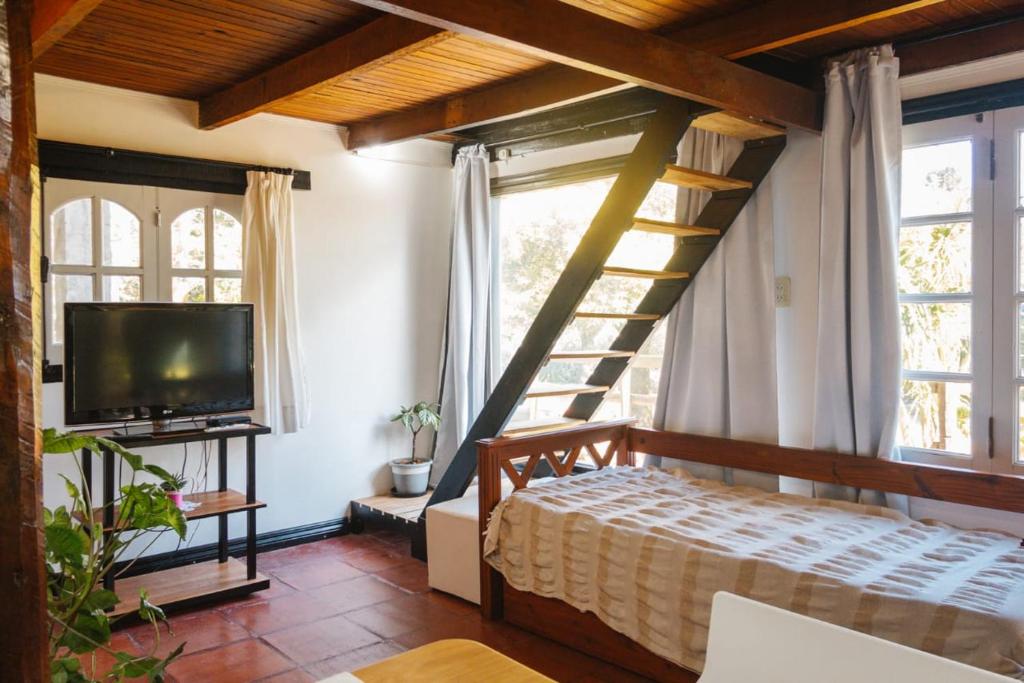 a bedroom with a staircase and a bed with a television at Solar de amigos in Tandil