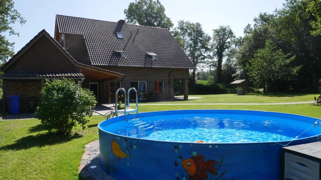 a large hot tub in the yard of a house at FeWo Lienen in Lienen