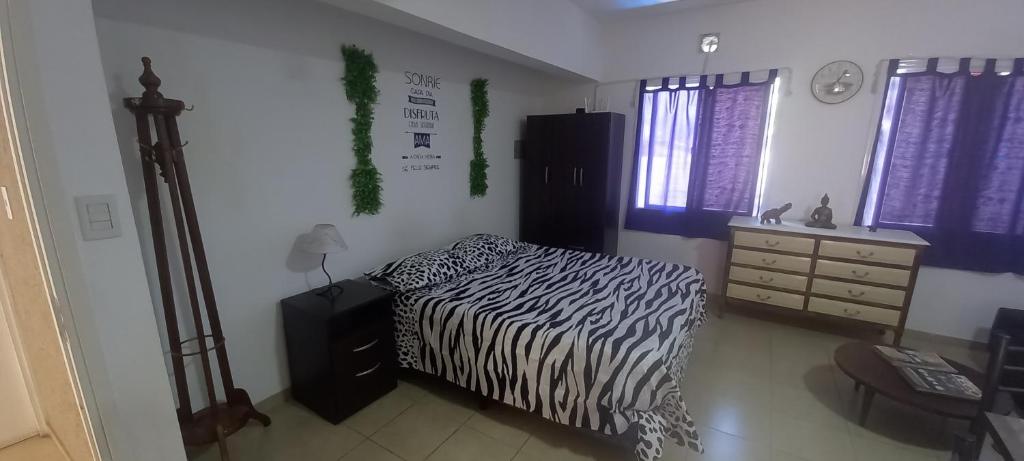 een slaapkamer met een bed met zebraprint en een dressoir bij Hermoso y cómodo apartamento.- in Mendoza