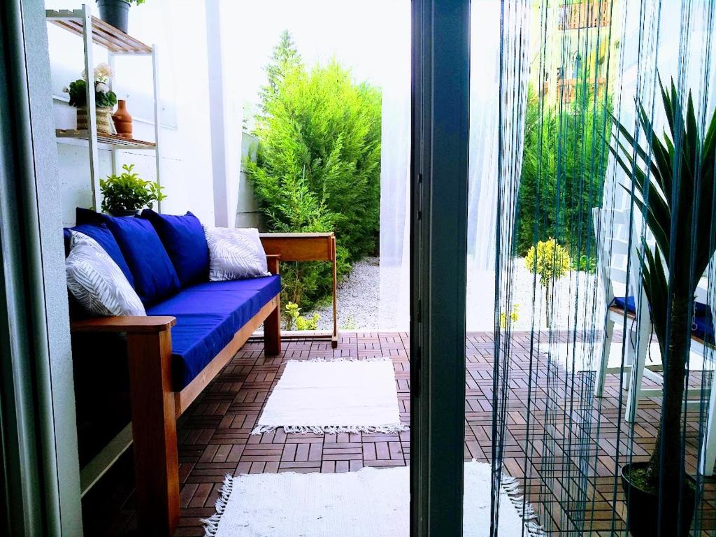 un porche con un sofá azul en el patio en Bomi Apartman, en Győr